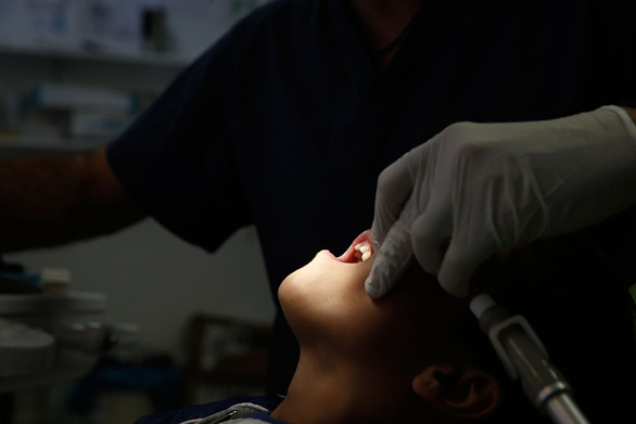 Kết quả nghiên cứu cho thấy có mối liên hệ giữa việc chăm sóc răng miệng và sự tiến triển của COVID-19 - Ảnh minh họa: Reuters