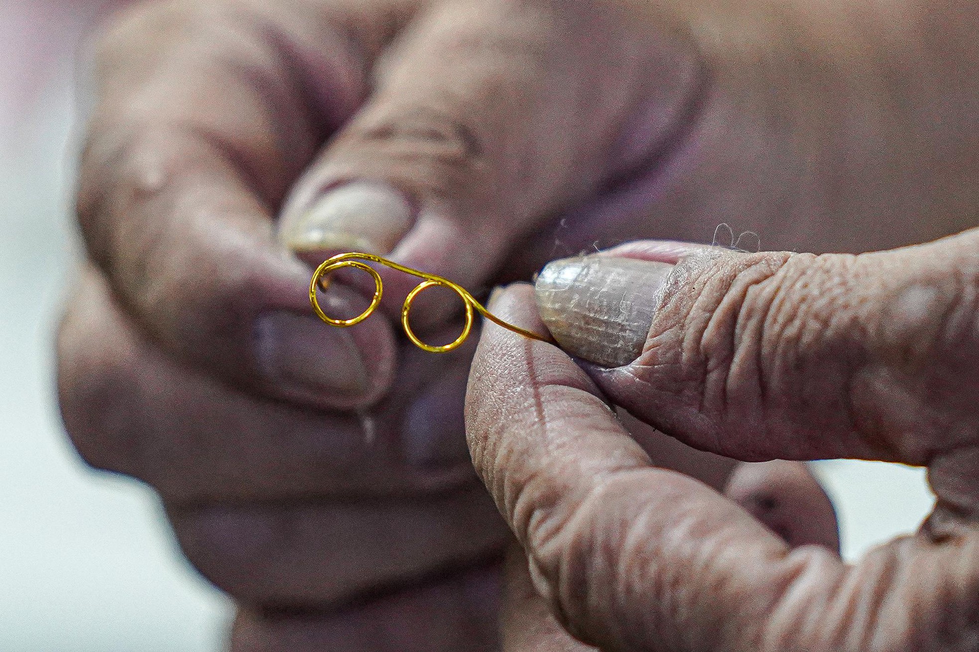 Cặp kính nhỏ bằng đường kính một chiếc đũa được uốn từ một đoạn dây đồng.